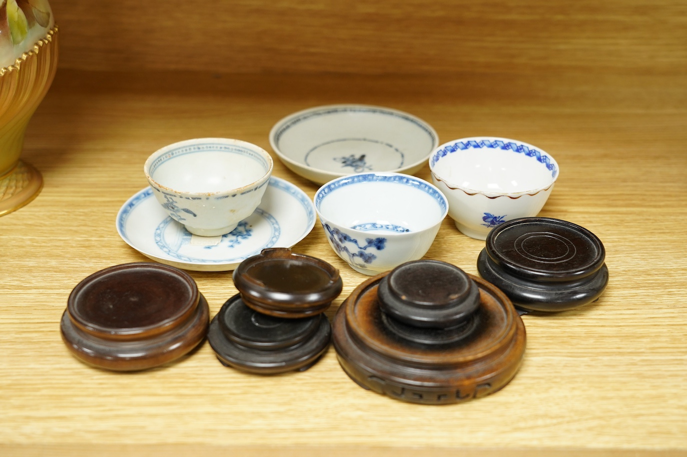 A Chinese Tek Sing Cargo tea bowl and saucer, a Nanking Cargo saucer, two other tea bowls and six small hardwood stands. Condition - fair